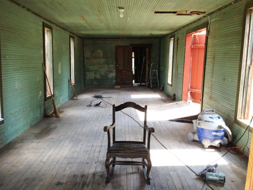 An old room with a rocking chair and tools, mid-renovation